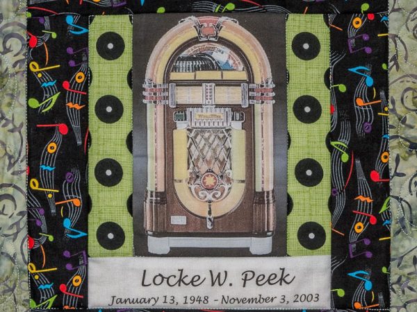 Quilt square for Locke Peek with a Juke Box at the center and a background of musical notes.