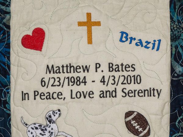 Quilt square for Matthew P. Bates with a heart, cross, Brazil, dalmation, football and text reading: In peace, love and serenity.
