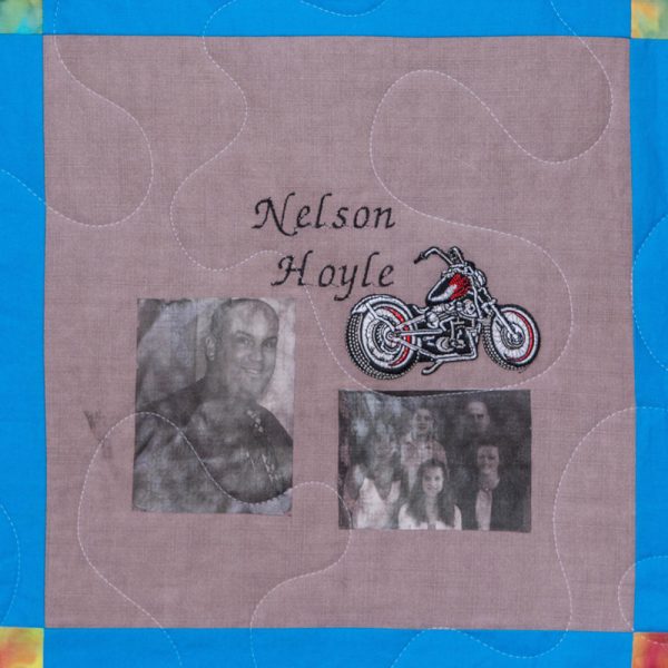 Quilt square for Nelson Hoyle with pictures of Nelson and his family, and a patch of a motorcycle.