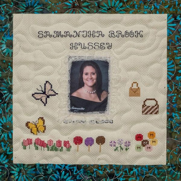 Quilt square for Samantha Hussey with purses, butterflies, flowers and a portrait of Samantha