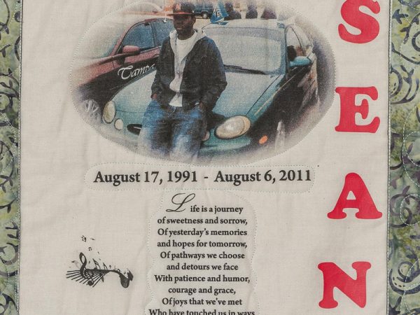 Quilt square for Sean Jones with photo of Sean sitting by a green sedan and a poem.