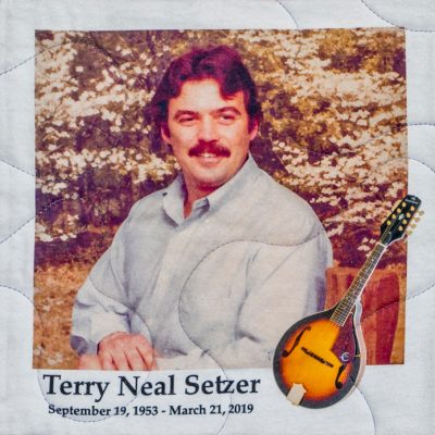 Quilt square for Terry Neal Setzer with an outdoor portrait photo of Terry and a guitar