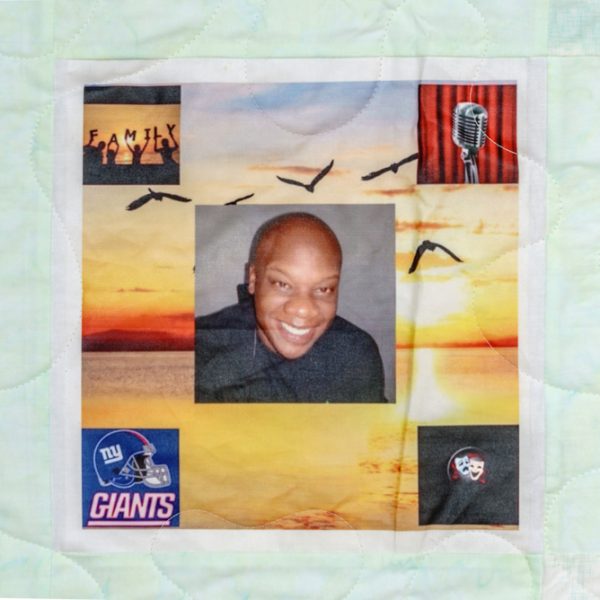 Quilt square for Tory Ellis with photo of Tory overlaying a background of a sunset, with patches of family, open mic, NY Giants, and comedy