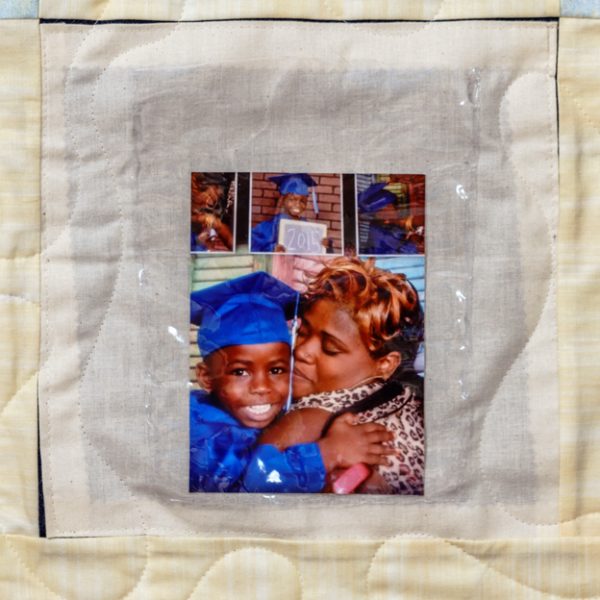 Quilt square for Juwaan Woodbury Jr. with a photo of a young Juwaan in a blue cap and gown.