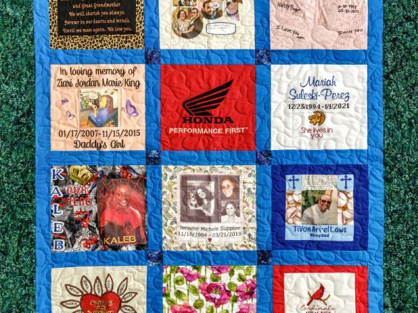 Colorful blue quilt with 12 unique squares featuring donor names, photos, and memories