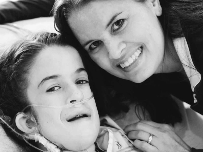 Courtney pictured in the hospital bed with her mother by her side