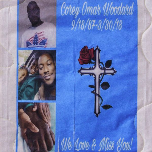 Quilt square for Corey Woodard with photos of Corey with family, a cross, and text reading: we love and miss you