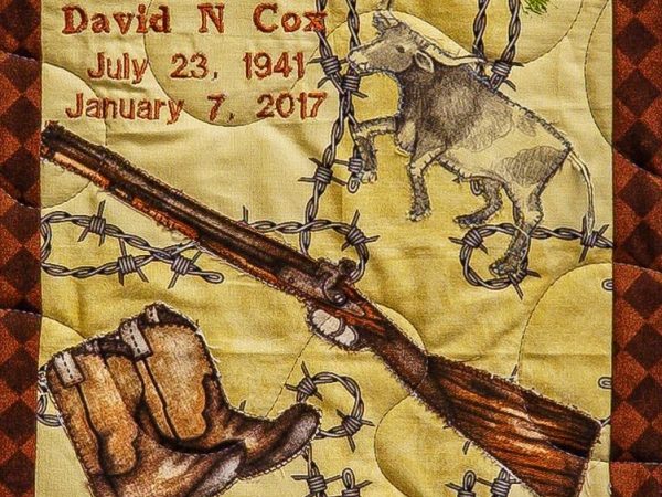 Quilt square for David Cox with patches of a rifle, cowboy boots, a steer, and fencing