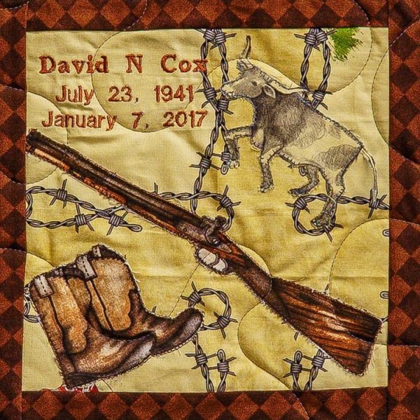 Quilt square for David Cox with patches of a rifle, cowboy boots, a steer, and fencing
