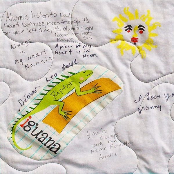 Quilt square for De'Mari Daye with handwritten messages and patches of an iguana and a son. Text reading: Always listen to your heart because even though it’s on your left side, it’s always right. Forever in my heart. Many loves. Son! Always in my heart. Nannie.