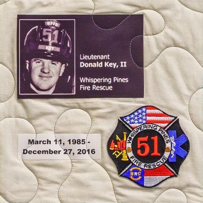 Quilt square for Donald Key II with a photo of Donald wearing his fire fighter helmet and a patch for Whispering Pines Fire Rescue #51