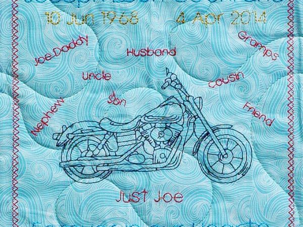 Quilt square for Joseph Cochrane with a motorcycle and text reading Joe Daddy, uncle, husband, son, nephew, friend, cousin, and gramps. Just Joe. Forever in our hearts.