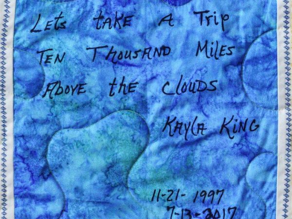 Quilt square for Kayla King with text reading: Let’s take a trip ten thousand miles above the clouds