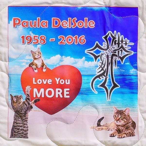 Quilt square for Paula DelSole with cats, a heart, a tropical beach, and a cross.