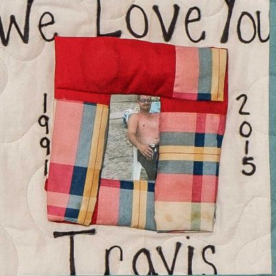 Quilt square for Travis Englebright with a photo of Travis at the beach and text reading: we love you Travis.