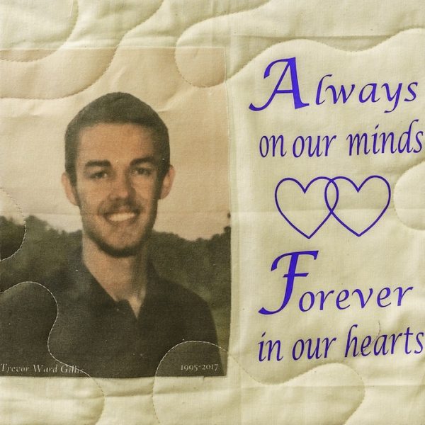 Quilt square for Trevor Gillis with an outdoor portrait of Trevor and text reading: Always on our minds. Forever in our hearts.