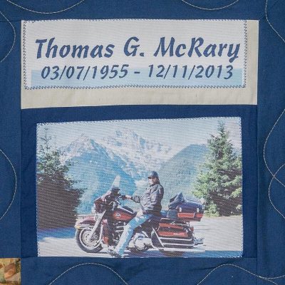 Quilt square for thomas McRary with photo of Thomas on a motor cycle in front of a mountain