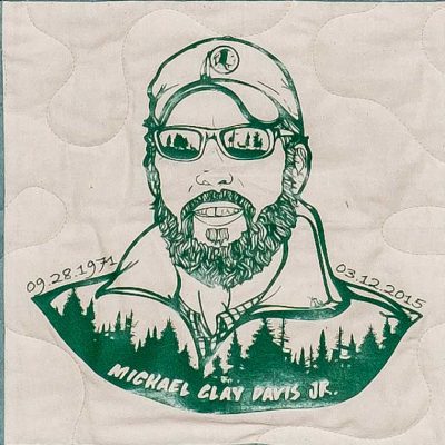 Quilt square for Michael Clay Davis Jr. with an illustration of Michael wearing a hat and forest overlay.