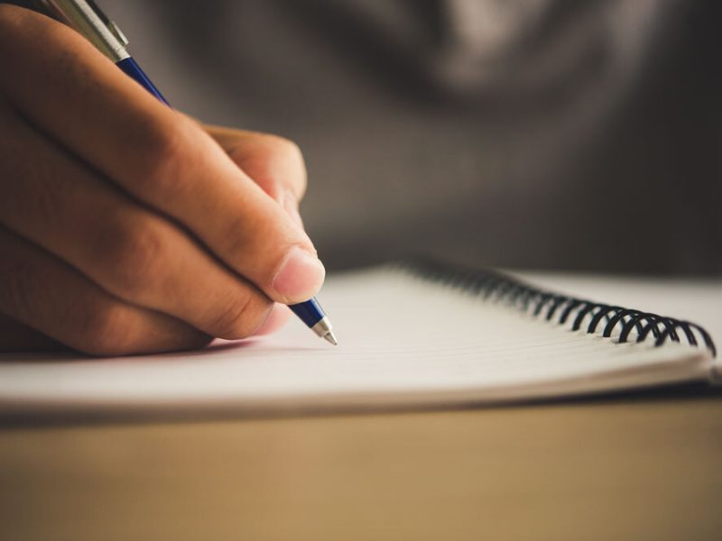 A woman writes something down in a notebook